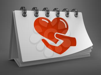 White Desktop Calendar with Red Icon of Heart in the Hand on Gray Background. Charity Concept.