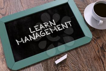 Handwritten Learn Management on a Blue Chalkboard. Top View Composition with Chalkboard and White Cup of Coffee. 3D Render.