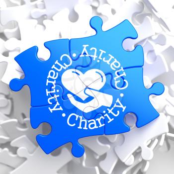 Charity Word Written Arround Icon of Heart in the Hand, Located on Blue Puzzle. Social Concept.