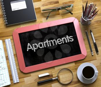 Apartments Handwritten on Red Chalkboard. Top View Composition with Small Chalkboard on Working Table with Office Supplies Around. Apartments on Small Chalkboard. 3d Rendering.