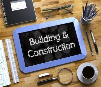 Building and Construction on Small Chalkboard. Top View of Office Desk with Stationery and Blue Small Chalkboard with Business Concept - Building and Construction. 3d Rendering.