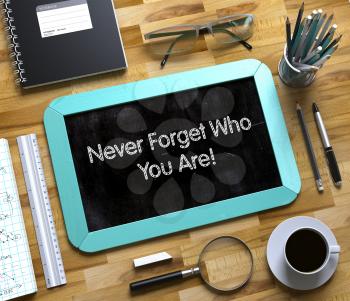 Never Forget Who You Are Concept on Small Chalkboard. Top View of Office Desk with Stationery and Mint Small Chalkboard with Business Concept - Never Forget Who You Are. 3d Rendering.