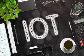 IOT Handwritten on Black Chalkboard. Top View of Black Office Desk with a Lot of Business and Office Supplies on It. 3d Rendering. Toned Image.