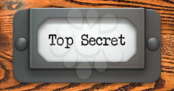 Top Secret - Inscription on File Drawer Label on a Wooden Background.