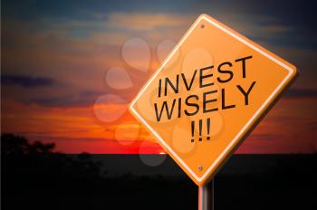 Invest Wisely on Warning Road Sign on Sunset Sky Background.