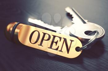 Keys and Golden Keyring with the Word Open over Black Wooden Table with Blur Effect. Toned Image.