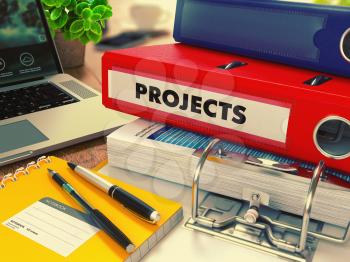 Red Office Folder with Inscription Projects on Office Desktop with Office Supplies and Modern Laptop. Business Concept on Blurred Background. Toned Image.