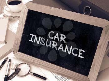 Car Insurance Handwritten by white Chalk on a Blackboard. Composition with Small Chalkboard on Background of Working Table with Office Folders, Stationery, Reports. Blurred Background. Toned Image.