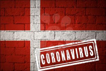 Flag of the Denmark with original proportions. stamped of Coronavirus. brick wall texture. Corona virus concept. On the verge of a COVID-19 or 2019-nCoV Pandemic.