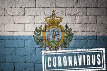 Flag of the San-Marino with original proportions. stamped of Coronavirus. brick wall texture. Corona virus concept. On the verge of a COVID-19 or 2019-nCoV Pandemic.