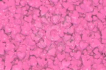 Valentine's Day abstract blurred 3D illustration or background pattern with shiny pink or rosy hearts.