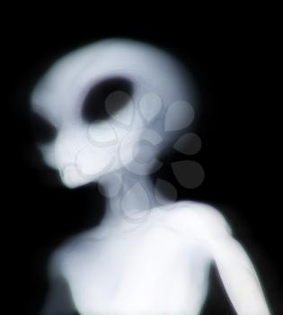 Grey alien illuminated as he passes through dimensions