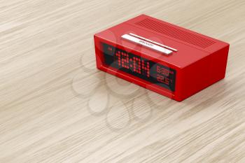 Red alarm clock on wood background