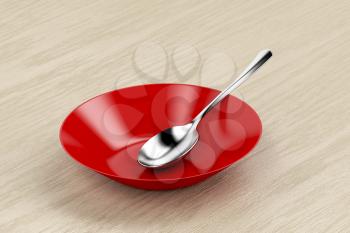 Red empty bowl and silver spoon on wood table