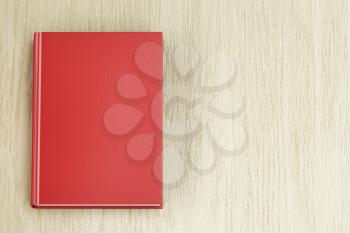 Red book on wooden table, top view