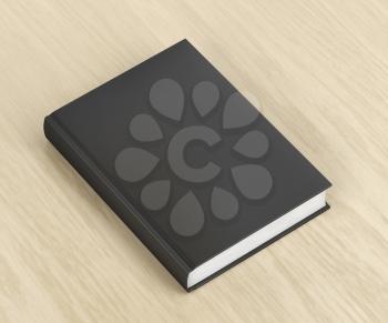 Book with black cover on wooden table