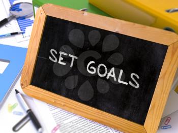 Set Goals Handwritten on Chalkboard. Composition with Small Chalkboard on Background of Working Table with Ring Binders, Office Supplies, Reports. Blurred Background. Toned Image. 3D Render.