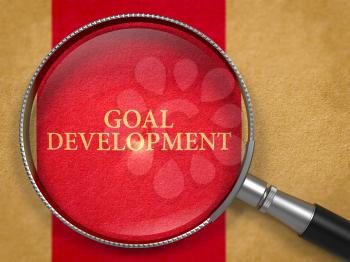 Goal Development Concept through Magnifier on Old Paper with Dark Red Vertical Line Background. 3D Render.