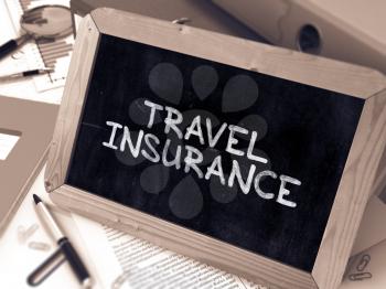 Travel Insurance Handwritten on Chalkboard. Composition with Small Chalkboard on Background of Working Table with Ring Binders, Office Supplies, Reports. Blurred Background. Toned Image. 3D Render.
