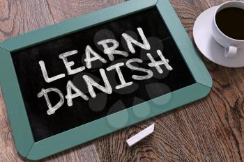 Learn Danish Concept Hand Drawn on Blue Chalkboard on Wooden Table. Business Background. Top View. 3D Render.