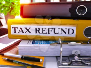 Tax Refund - Yellow Office Folder on Background of Working Table with Stationery and Laptop. Tax Refund Business Concept on Blurred Background. Tax Refund Toned Image. 3D.