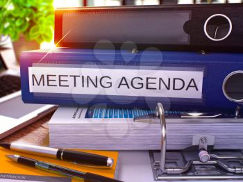 Meeting Agenda - Blue Ring Binder on Office Desktop with Office Supplies and Modern Laptop. Meeting Agenda Business Concept on Blurred Background. Meeting Agenda - Toned Illustration. 3D Render.