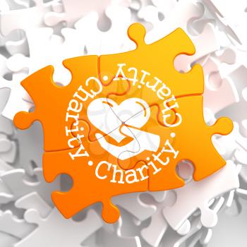 Charity Word Written Arround Icon of Heart in the Hand, Located on Orange Puzzle. Social Concept.