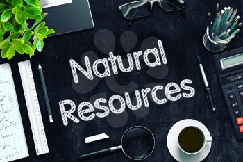 Natural Resources. Business Concept Handwritten on Black Chalkboard. Top View Composition with Chalkboard and Office Supplies. 3d Rendering. Toned Illustration.
