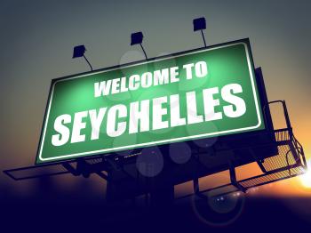 Welcome to Seychelles - Green Billboard on the Rising Sun Background.