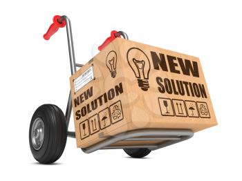 New Solution Slogan on Cardboard Box on Hand Truck White Background.