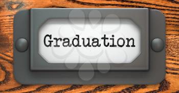 Graduation - Inscription on File Drawer Label on a Wooden Background.