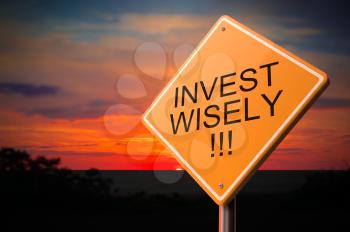Invest Wisely on Warning Road Sign on Sunset Sky Background.