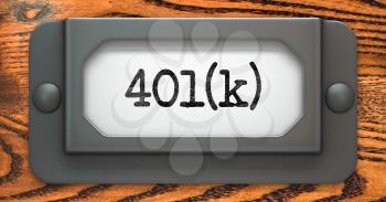 Inscription 401K on File Drawer Label on a Wooden Background.