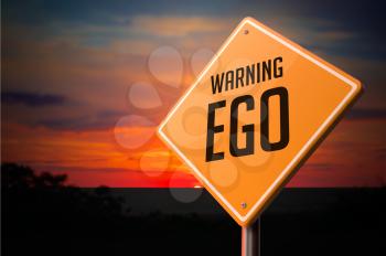 EGO on Warning Road Sign on Sunset Sky Background.