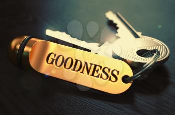 Keys and Golden Keyring with the Word Goodness over Black Wooden Table with Blur Effect. Toned Image.