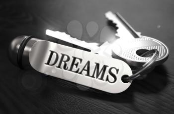 Keys to Dreams - Concept on Golden Keychain over Black Wooden Background. Closeup View, Selective Focus, 3D Render. Black and White Image.