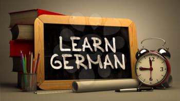 Learn German Concept Hand Drawn on Chalkboard. Blurred Background. Toned Image.