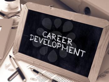 Career Development Handwritten by white Chalk on a Blackboard. Composition with Small Chalkboard on Background of Working Table with Office Folders, Stationery, Reports. Blurred, Toned Image.