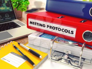 Meeting Protocols - Red Office Folder on Background of Working Table with Stationery, Laptop and Reports. Business Concept on Blurred Background. Toned Image.