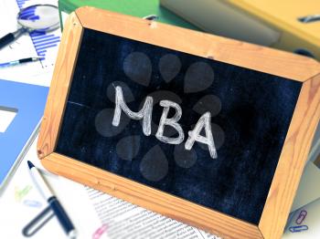 MBA - Master Business Administration - Concept Hand Drawn on Chalkboard on Working Table Background. Blurred Background. Toned Image.