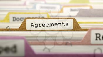 File Folder Labeled as Agreements in Multicolor Archive. Closeup View. Blurred Image.