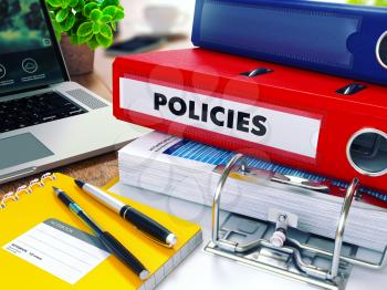 Policies - Red Ring Binder on Office Desktop with Office Supplies and Modern Laptop. Business Concept on Blurred Background. Toned Illustration.