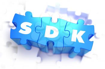 SDK - Software Development Kit - Text on Blue Puzzles on White Background. 3D Render. 
