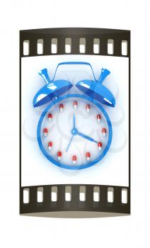 Alarm clock and tablet on a white background. The film strip