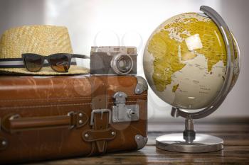 Tourism and travel concept. Globe and vintage suitcase with summer hat, sunglasses photo camera on wooden table. 3d illustration