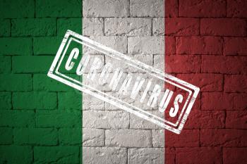 Flag of the Italy with original proportions. stamped of Coronavirus. brick wall texture. Corona virus concept. On the verge of a COVID-19 or 2019-nCoV Pandemic.