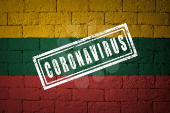 Flag of the Lithuania with original proportions. stamped of Coronavirus. brick wall texture. Corona virus concept. On the verge of a COVID-19 or 2019-nCoV Pandemic.