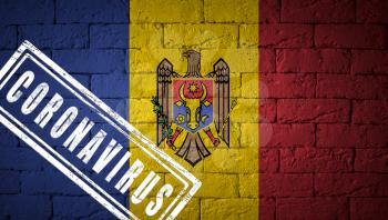 Flag of the Moldova with original proportions. stamped of Coronavirus. brick wall texture. Corona virus concept. On the verge of a COVID-19 or 2019-nCoV Pandemic.