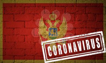 Flag of the Montenegro with original proportions. stamped of Coronavirus. brick wall texture. Corona virus concept. On the verge of a COVID-19 or 2019-nCoV Pandemic.