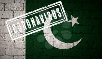 Flag of the Pakistan with original proportions. stamped of Coronavirus. brick wall texture. Corona virus concept. On the verge of a COVID-19 or 2019-nCoV Pandemic.